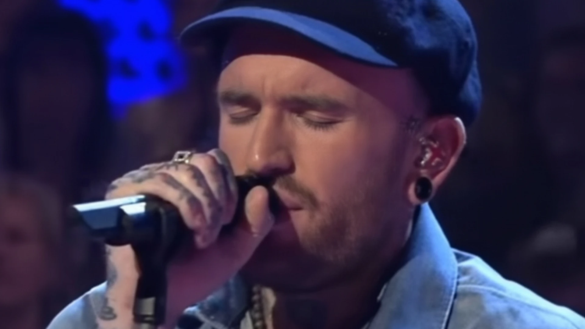 Ben Saunders zingt met gesloten ogen op een podium