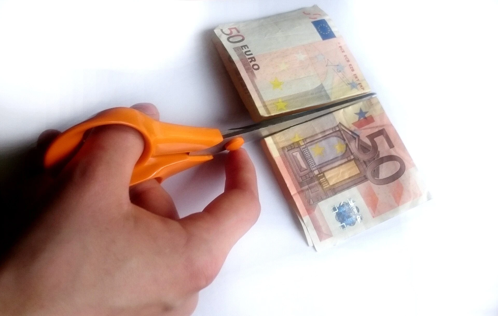 Schaar knipt in een briefje van vijftig euro