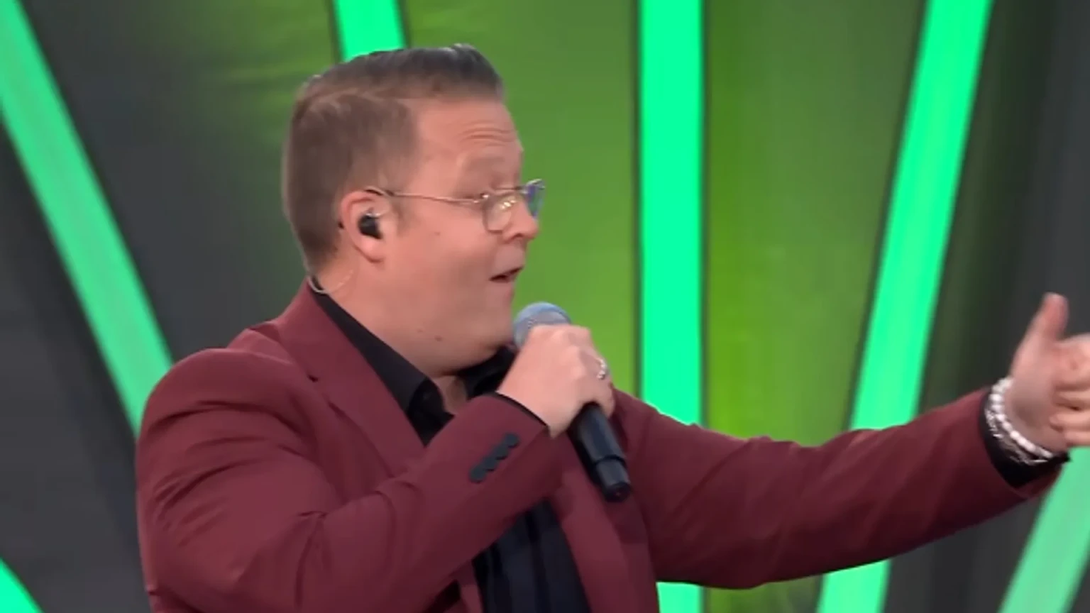 Rutger van Barneveld zingt in een rood colbert